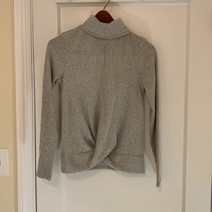 Super soft gray turtleneck sweater with twist at waist.
